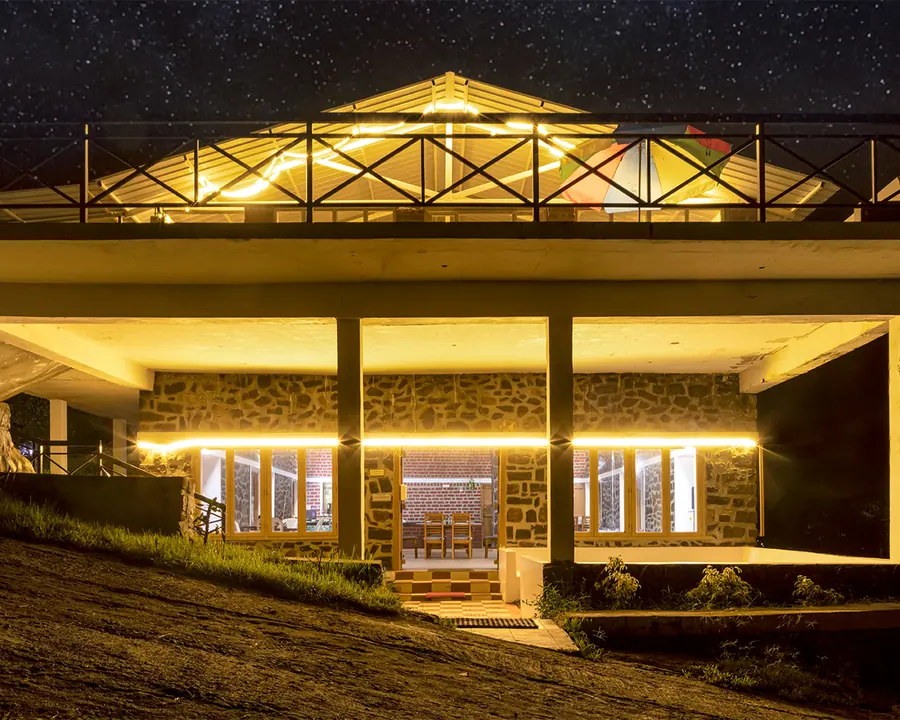 The club house lit up after dark, dining room and terrace