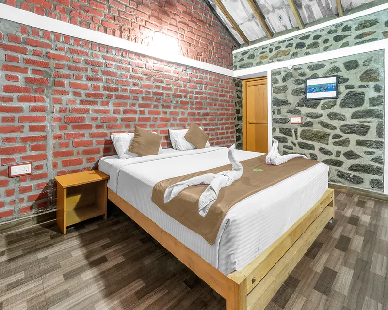The Garden View Suite, brick and stone walls with a king bed