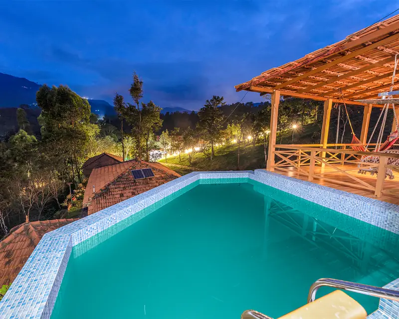 The private pool of the largest villa, lit at dusk above the valley