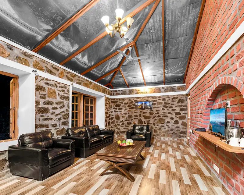 The living room of a two bedroom villa, stone and brick with seating for the family